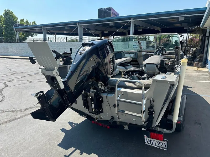 Slide: The Image of 2015 Alumacraft Competitor 165 Sport boat with Mercury outboard motor in a parking lot. - 9