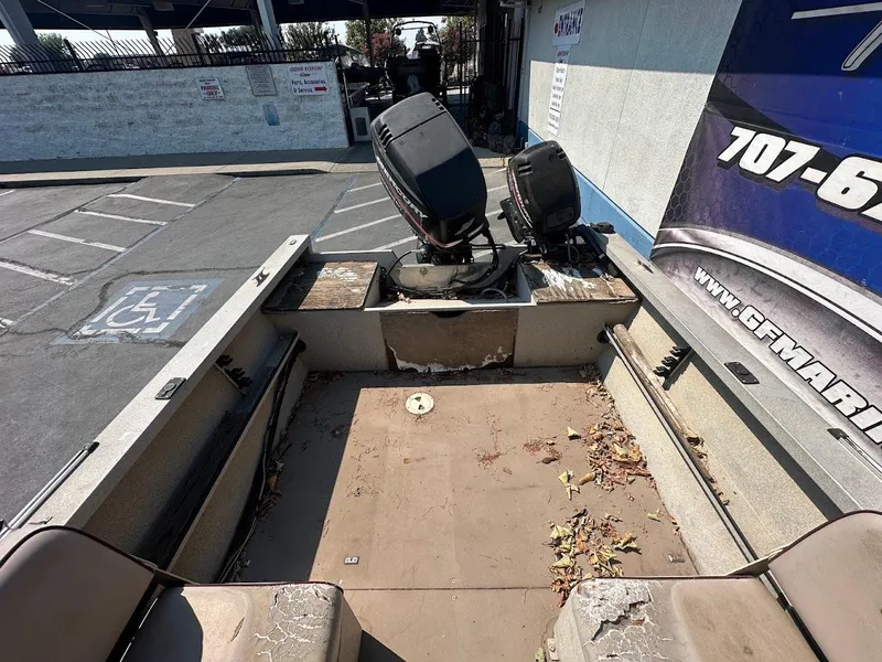 Slide: The Image of 2003 Alumaweld Stryker boat interior with dual outboard motors, parked in a lot. - 11