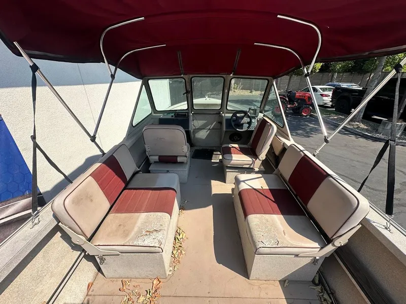 Slide: The Image of 2003 Alumaweld Stryker boat interior with red and beige seating under a canopy. - 13