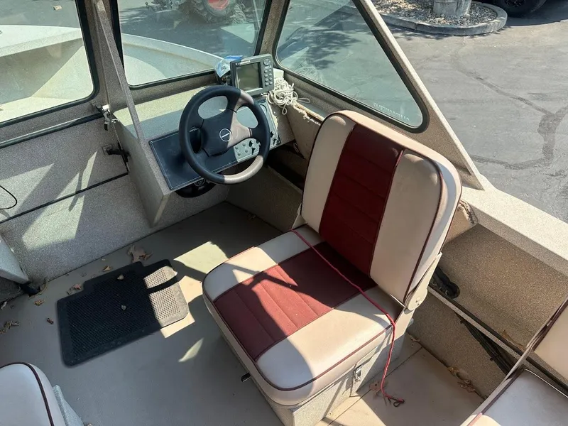 Slide: The Image of 2003 Alumaweld Stryker boat interior with steering wheel and cushioned seat. - 16