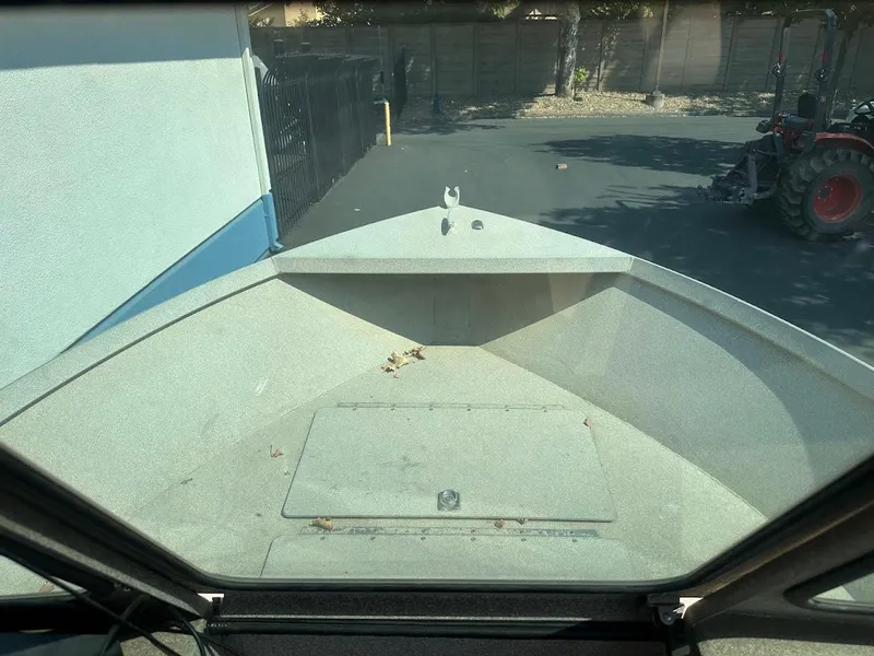 Slide: The Image of 2003 Alumaweld Stryker boat interior view, parked near a building and tractor. - 19