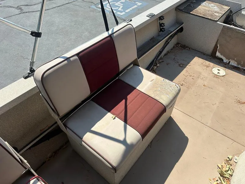 Slide: The Image of 2003 Alumaweld Stryker boat seat with red and beige upholstery, showing signs of wear. - 20