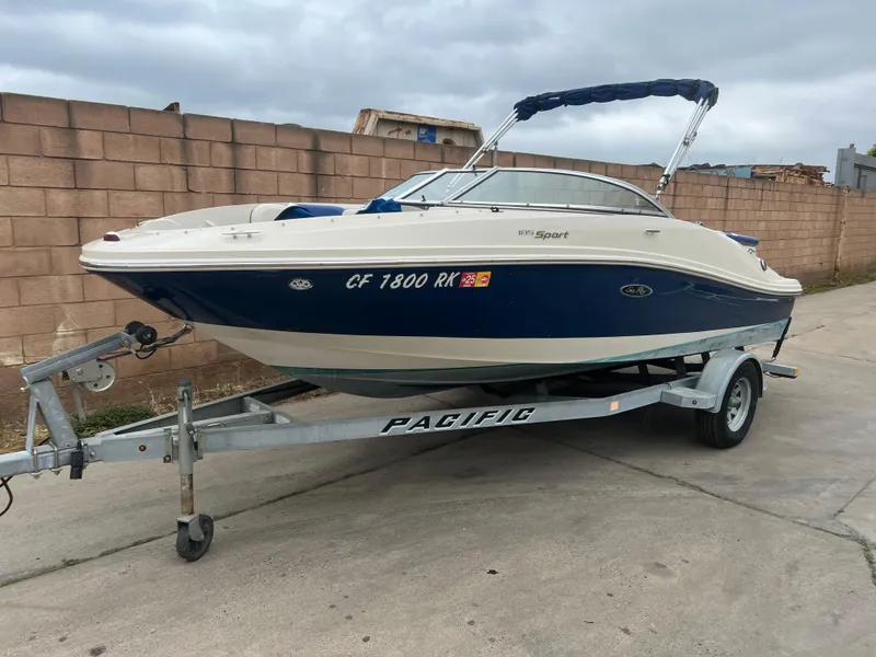 The Image of 2007 Sea Ray 185 Sport boat on trailer, parked outdoors. - 0
