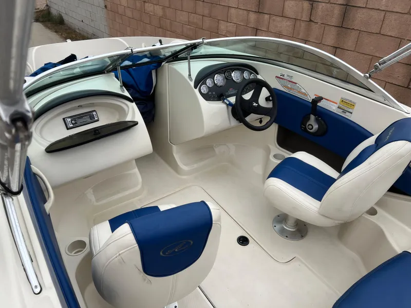 Slide: The Image of 2007 Sea Ray 185 Sport boat interior with blue and white seating and dashboard controls. - 3