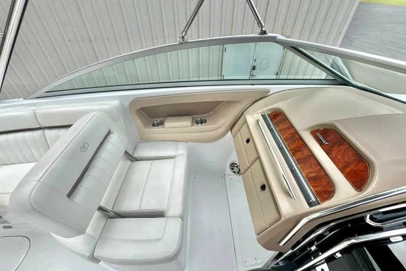 Slide: The Image of 2008 Cobalt 323 boat interior with white seating and wood-accented dashboard. - 12