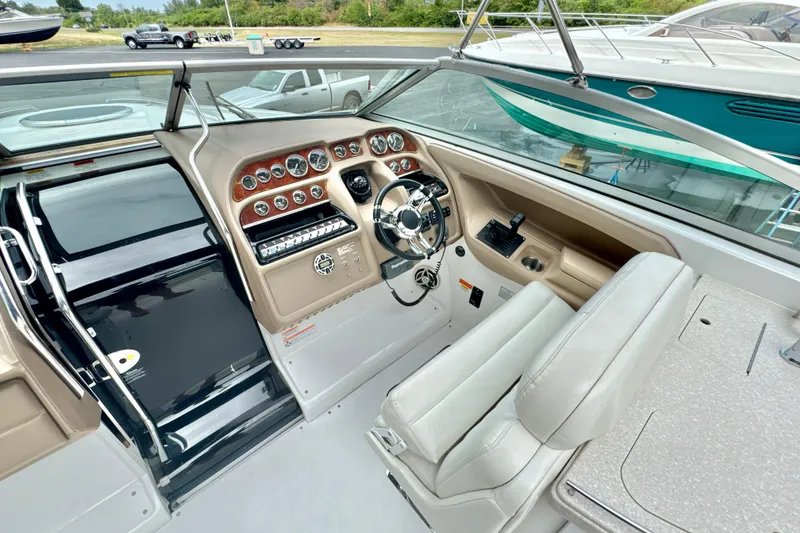 Slide: The Image of 2008 Cobalt 323 boat cockpit with steering wheel, control panel, and comfortable seating. - 13