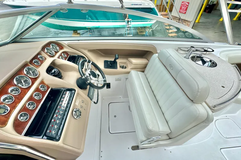 Slide: The Image of 2008 Cobalt 323 boat interior with steering wheel, dashboard, and white leather seating. - 16