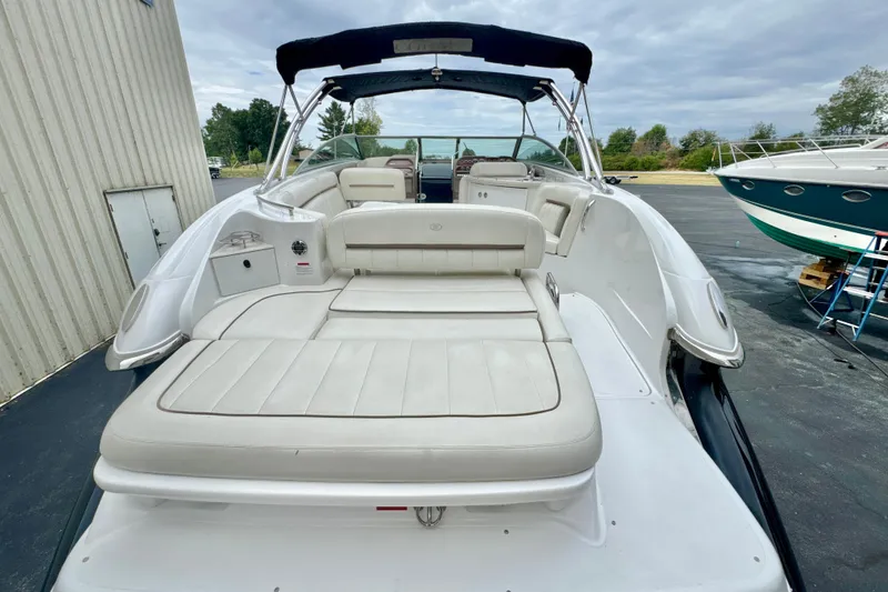 Slide: The Image of 2008 Cobalt 323 boat with spacious white seating and sleek design, docked outdoors. - 4