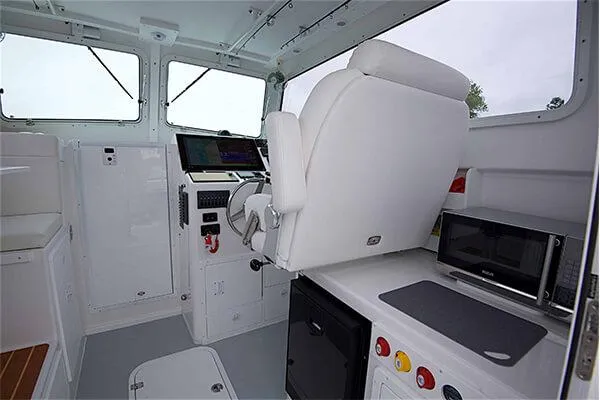 Slide: The Image of Interior of 2026 Steiger Craft 28 Miami boat with helm, seating, and kitchenette. - 23