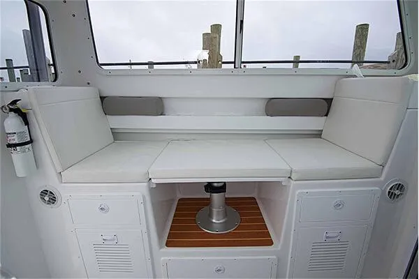 Slide: The Image of Interior seating of 2026 Steiger Craft 28 Miami boat, featuring white cushions and storage compartments. - 24