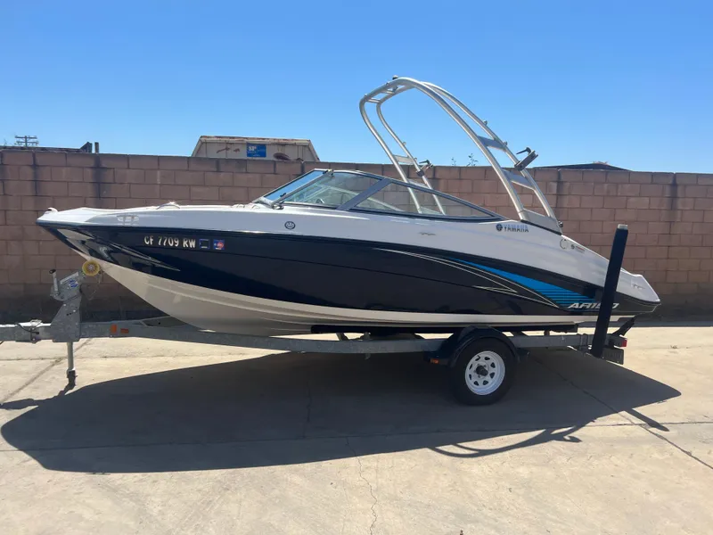 Slide: The Image of 2016 Yamaha AR190 boat on trailer, parked outdoors against a brick wall. - 0
