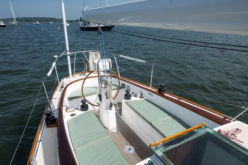 Slide: The Image of Sailboat deck view of 2005 Morris M36 on calm water, featuring seating and steering wheel. - 12