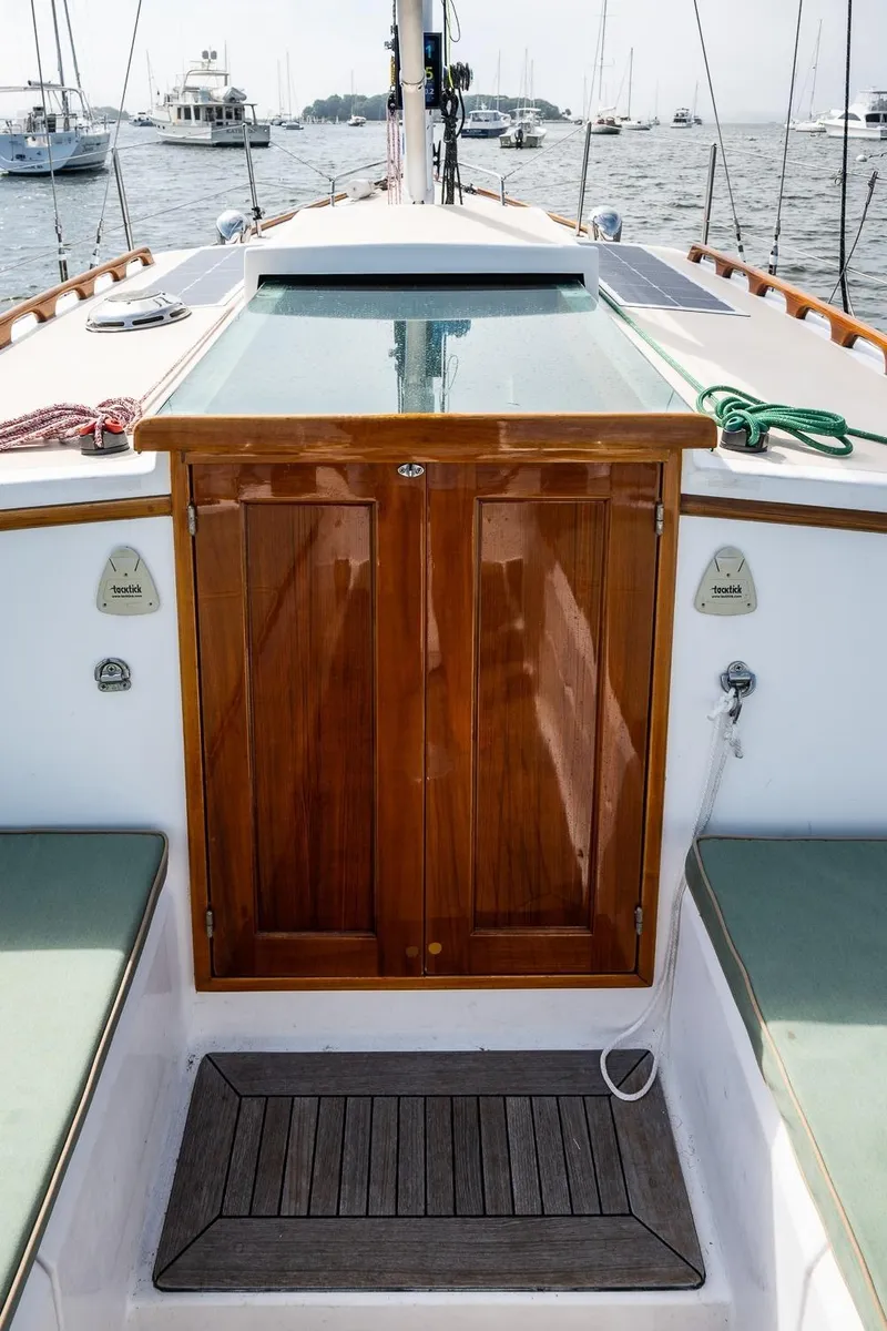 Slide: The Image of 2005 Morris M36 sailboat cockpit with wooden hatch, green ropes, and marina view. - 21