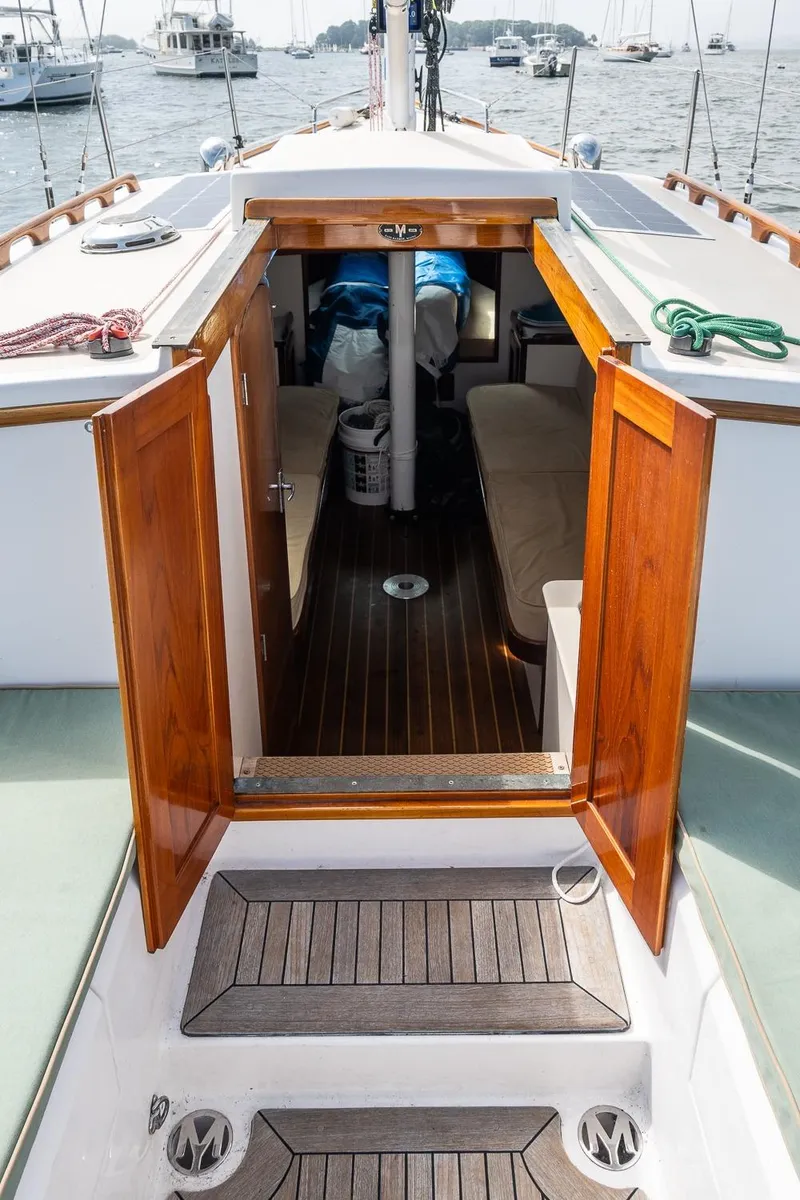 Slide: The Image of 2005 Morris M36 sailboat interior with open wooden doors, docked in a marina. - 22