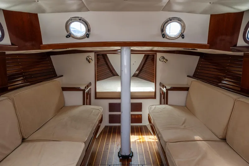 Slide: The Image of Interior of a 2005 Morris M36 sailboat, featuring cozy seating and wooden accents. - 24