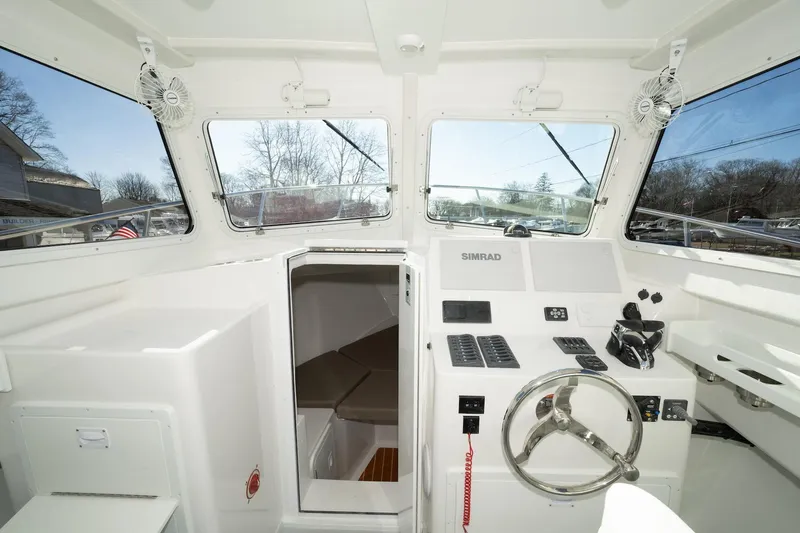 Slide: The Image of 2026 Steiger Craft 28 Fisherman boat interior with steering wheel and control panel. - 5