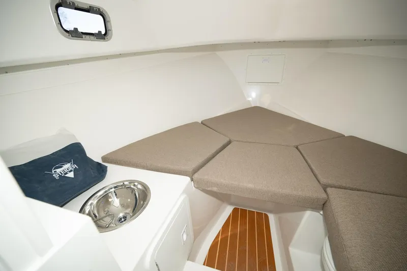 Slide: The Image of 2026 Steiger Craft 28 Fisherman cabin interior with cushioned seating and sink. - 6