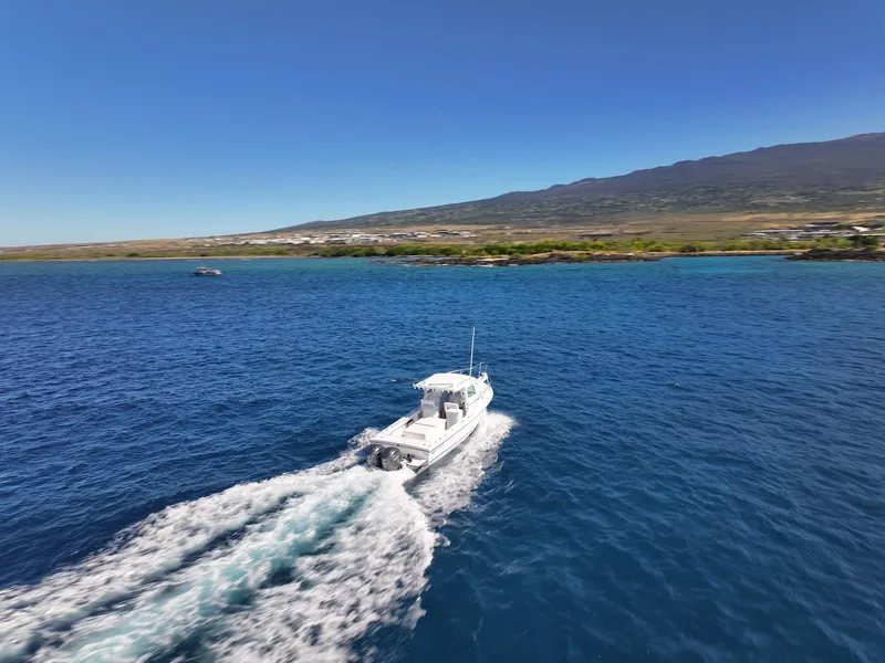 Slide: The Image of Steiger Craft 28 Hawaii 2026 boat cruising on blue ocean near scenic coastline. - 14