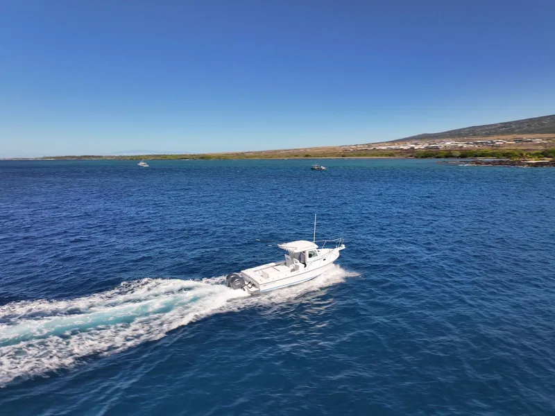 Slide: The Image of Steiger Craft 28 Hawaii 2026 boat cruising on blue ocean near scenic coastline. - 15