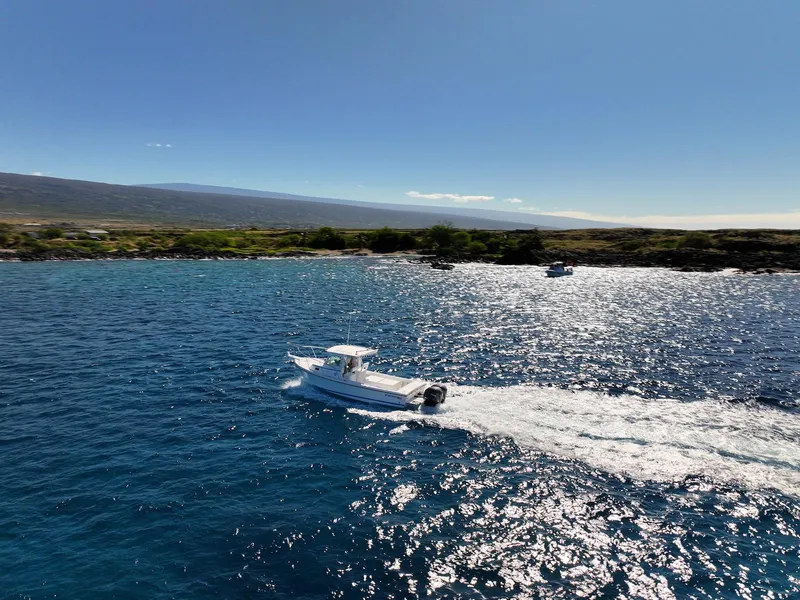 Slide: The Image of 2026 Steiger Craft 28 Hawaii boat cruising on sparkling blue ocean near scenic coastline. - 19
