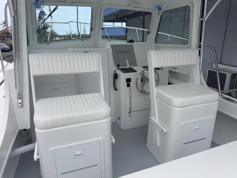 Slide: The Image of Interior of 2026 Steiger Craft 28 Hawaii boat with white seating and navigation equipment. - 24
