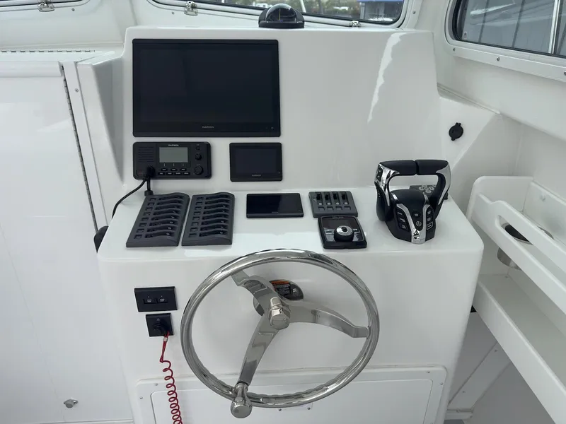 Slide: The Image of Steiger Craft 28 Hawaii 2026 boat dashboard with steering wheel and navigation controls. - 26