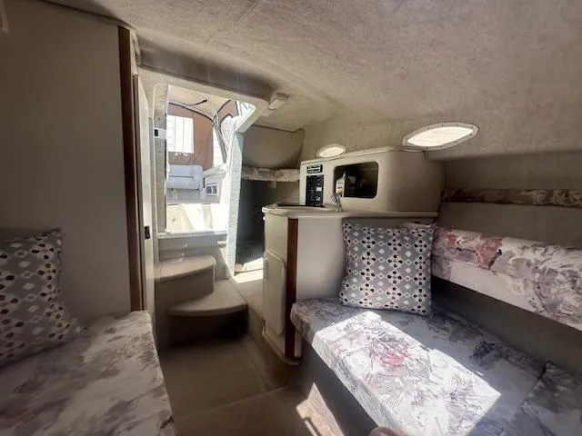 Slide: The Image of Interior of 1997 Sea Ray 240 Sundancer boat, featuring cozy seating and compact design. - 11