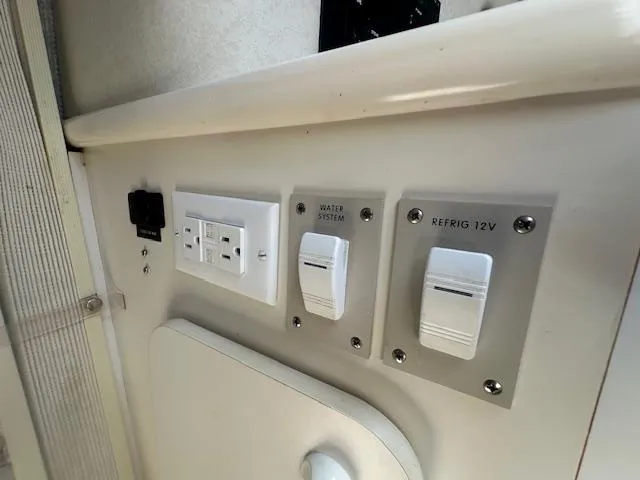 Slide: The Image of Control panel of a 1997 Sea Ray 240 Sundancer boat, featuring switches and outlets. - 14