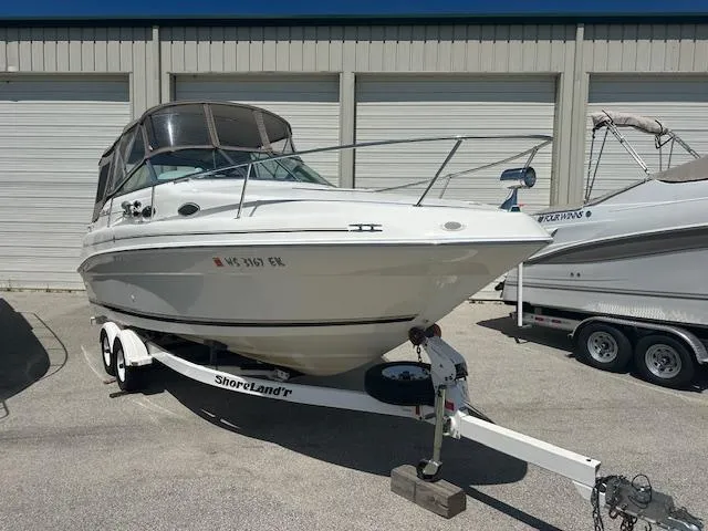 Slide: The Image of 1997 Sea Ray 240 Sundancer boat on trailer, parked outdoors. - 2