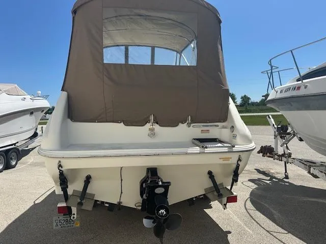 Slide: The Image of 1997 Sea Ray 240 Sundancer boat, rear view with brown canopy, parked on trailer. - 4