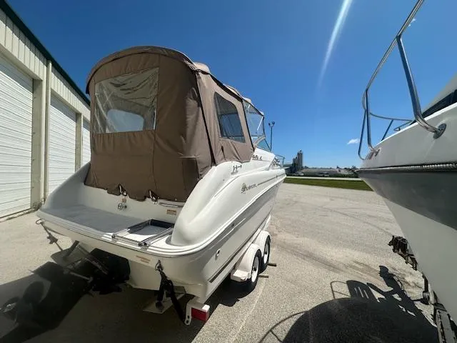 Slide: The Image of 1997 Sea Ray 240 Sundancer boat on trailer, parked outdoors under clear blue sky. - 5