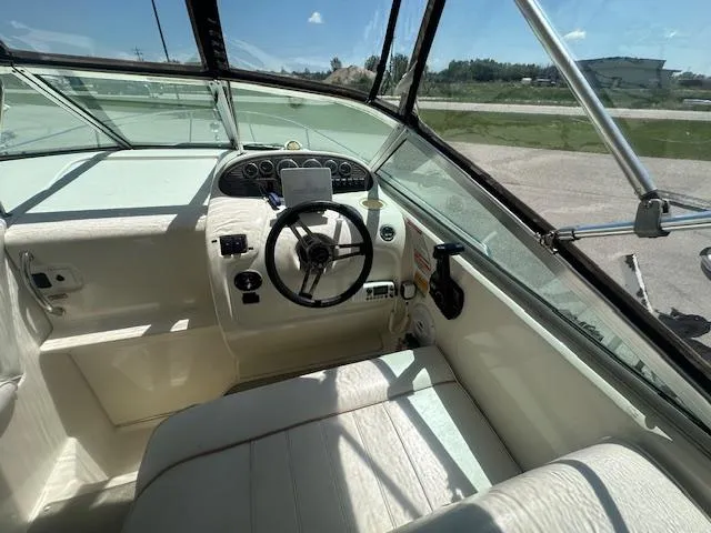 Slide: The Image of 1997 Sea Ray 240 Sundancer boat cockpit with steering wheel and dashboard controls. - 7
