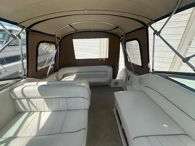 Slide: The Image of 1997 Sea Ray 240 Sundancer interior with white seating and brown canopy. - 8