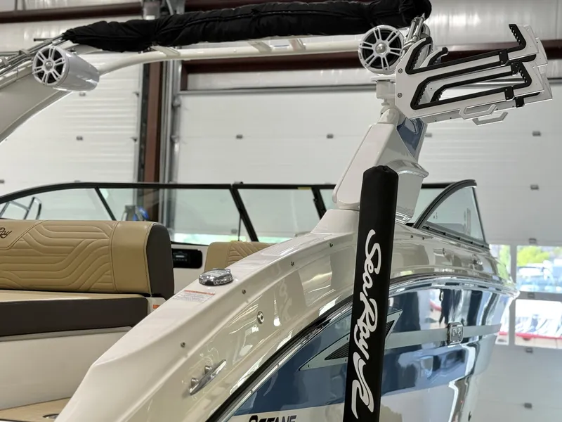 Slide: The Image of 2025 Sea Ray SDX250 Surf boat interior with tan seating and wakeboard rack. - 10