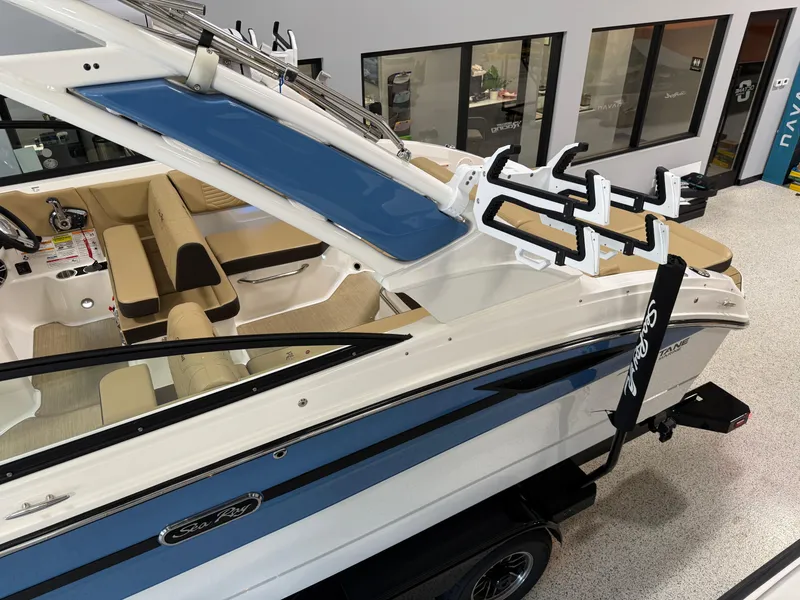 Slide: The Image of 2025 Sea Ray SDX250 Surf boat interior with beige seating and blue accents. - 14