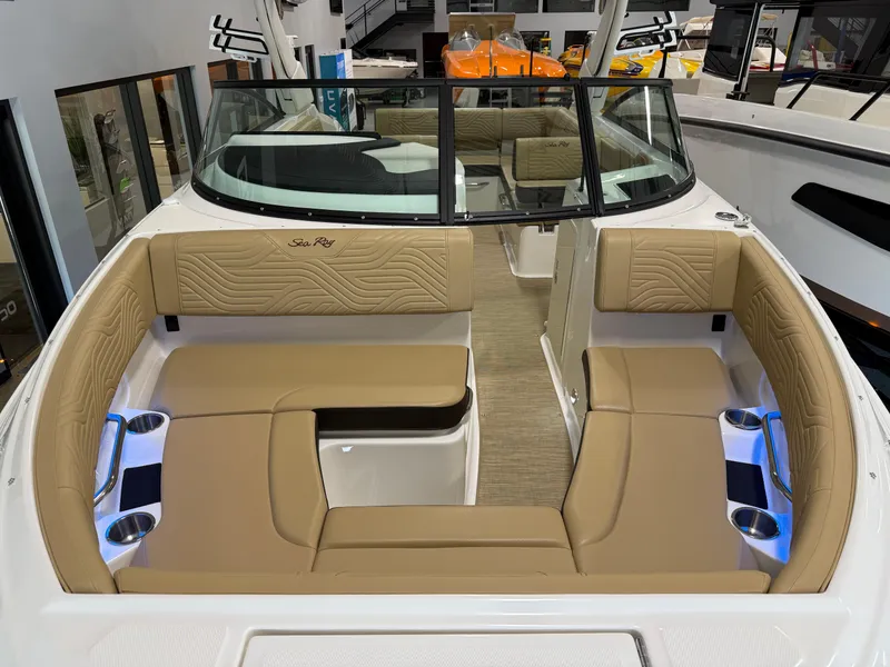 Slide: The Image of 2025 Sea Ray SDX250 Surf boat interior with tan seating and cup holders. - 18