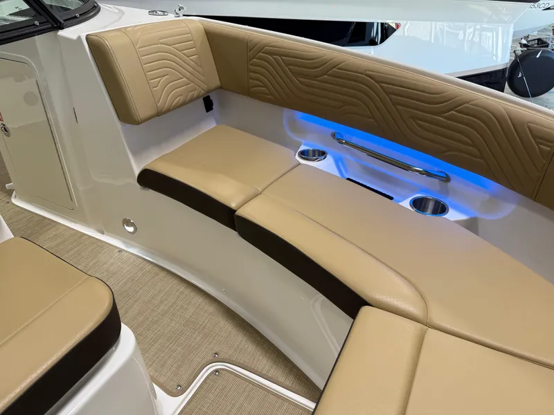 Slide: The Image of 2025 Sea Ray SDX250 Surf boat interior with tan seating and blue LED lighting. - 20