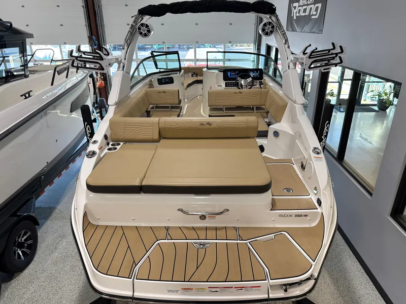 Slide: The Image of 2025 Sea Ray SDX250 Surf boat interior with tan seating and modern dashboard. - 32
