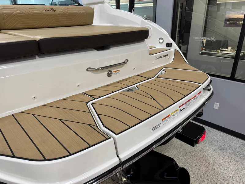 Slide: The Image of 2025 Sea Ray SDX250 Surf boat with teak-style swim platform and cushioned seating. - 33