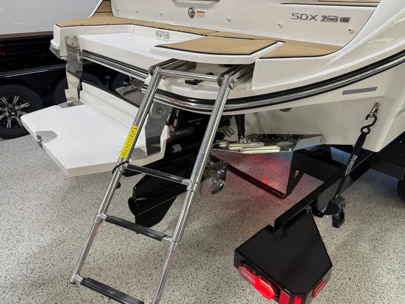 Slide: The Image of 2025 Sea Ray SDX250 Surf boat with swim platform and ladder in a showroom. - 37