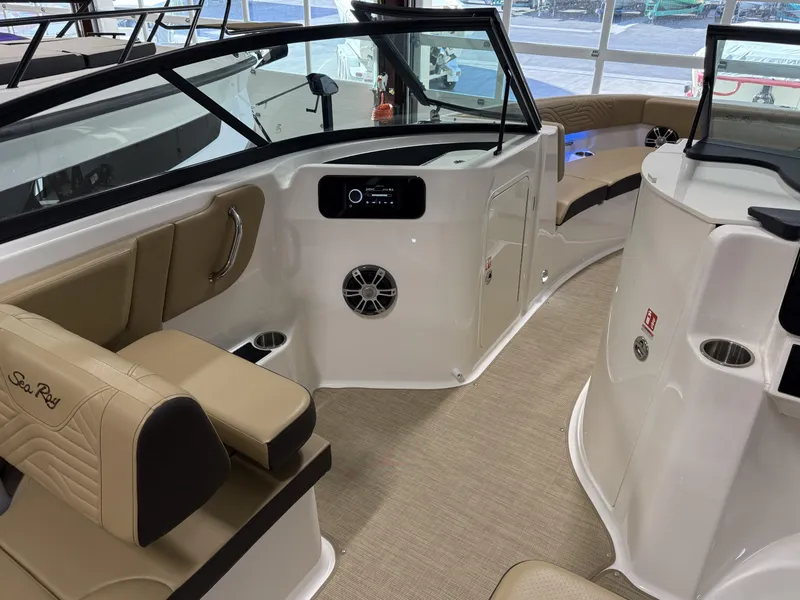 Slide: The Image of 2025 Sea Ray SDX250 Surf boat interior with beige seating and modern dashboard. - 42
