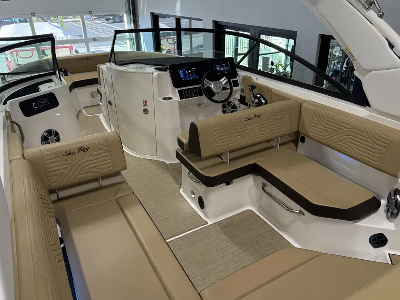 Slide: The Image of 2025 Sea Ray SDX250 Surf boat interior with beige seating and modern dashboard. - 43