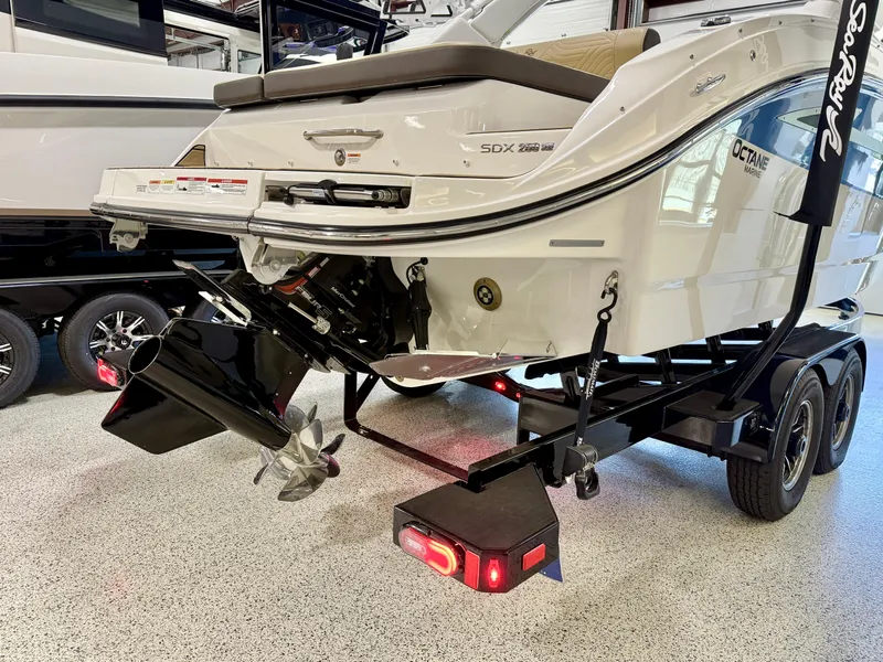 Slide: The Image of 2025 Sea Ray SDX250 Surf boat on trailer, showcasing rear view and propeller. - 9