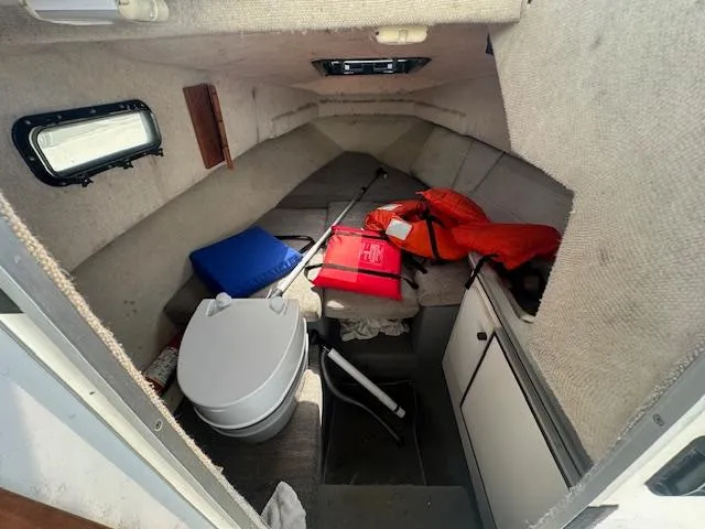 Slide: The Image of 1995 Bayliner Trophy cabin interior with life jackets, cushions, and a portable toilet. - 10