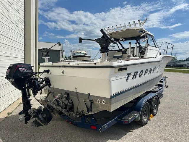 Slide: The Image of 1995 Bayliner Trophy boat on trailer, parked outdoors under a blue sky. - 4