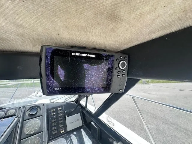 Slide: The Image of 1995 Bayliner Trophy boat dashboard with Humminbird Helix 7 and Garmin devices. - 7