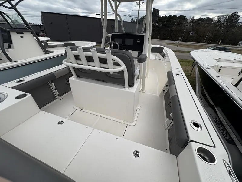 Slide: The Image of 2023 Sea Born LX22 boat interior with seating and rod holders, under cloudy sky. - 5