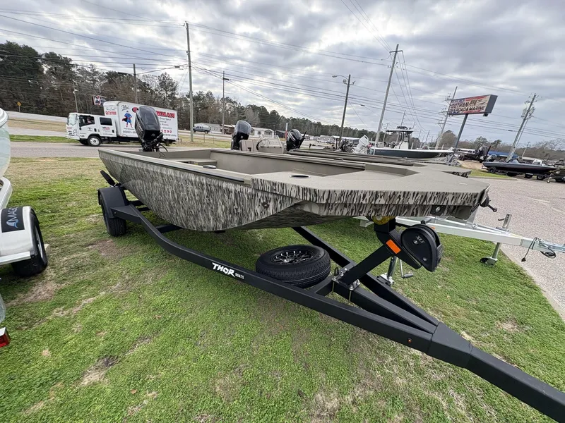 Slide: The Image of 2025 Thor Lake Hammer Hybrid 1754 boat on trailer, displayed outdoors under cloudy sky. - 1