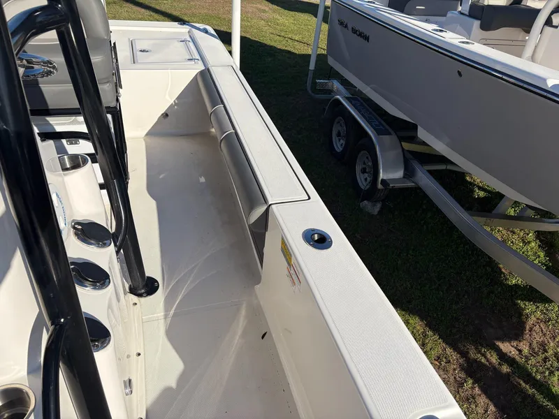 Slide: The Image of 2024 Sea Born FX FX24 boat interior with seating and cup holders, displayed on a trailer. - 12