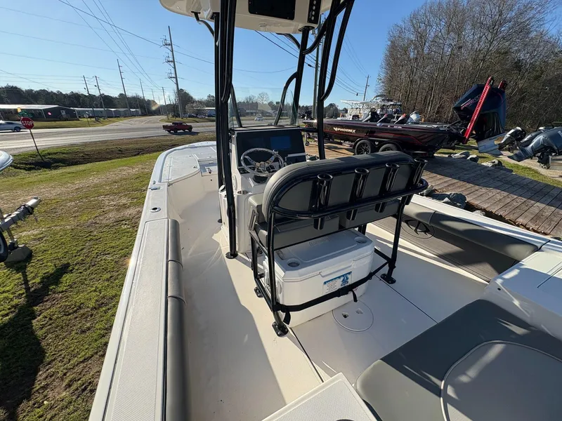 Slide: The Image of 2024 Sea Born FX FX24 boat interior with steering console and seating, parked outdoors. - 6